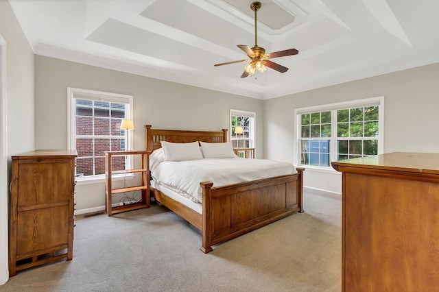 carpeted bedroom with ceiling fan, ornamental molding, and a tray ceiling