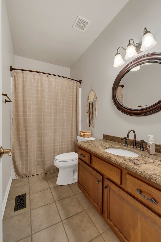 bathroom featuring tile patterned flooring, vanity, and toilet