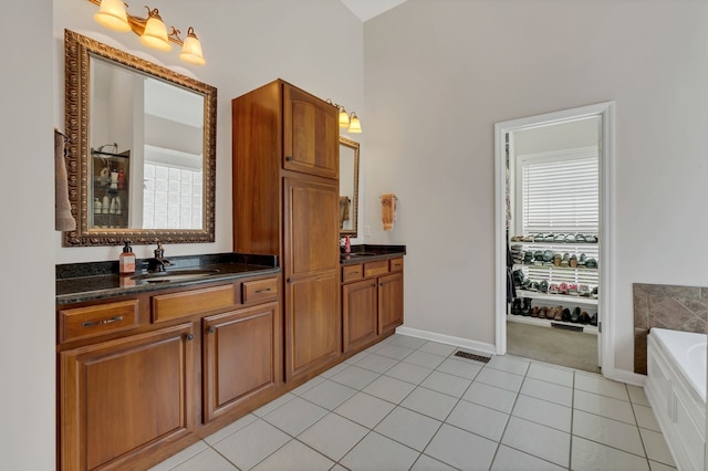 bathroom with tile patterned flooring, vanity, and a bathtub