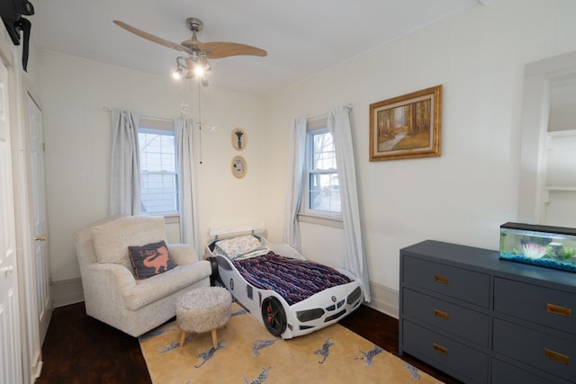 bedroom with dark hardwood / wood-style floors and ceiling fan