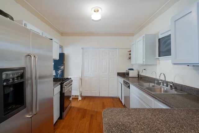 kitchen featuring sink, white cabinetry, stainless steel appliances, and light hardwood / wood-style flooring