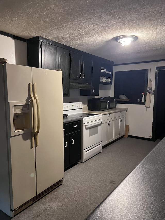 kitchen with a textured ceiling, carpet floors, and white appliances