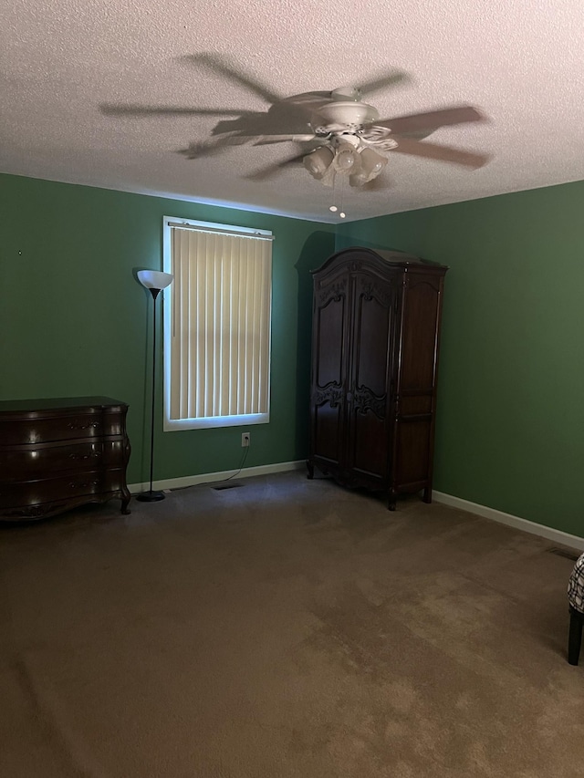 unfurnished bedroom with carpet, ceiling fan, and a textured ceiling