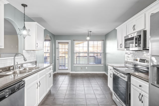 kitchen featuring hanging light fixtures, sink, decorative backsplash, appliances with stainless steel finishes, and white cabinetry