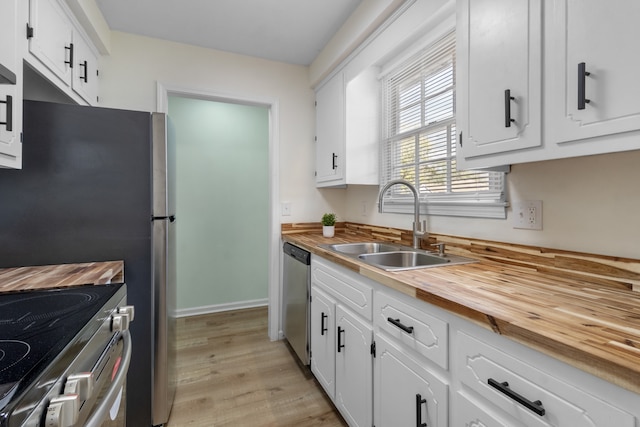 kitchen with sink, light wood-type flooring, white cabinetry, and stainless steel appliances