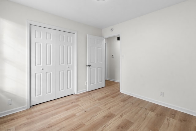 unfurnished bedroom featuring a closet and light hardwood / wood-style floors