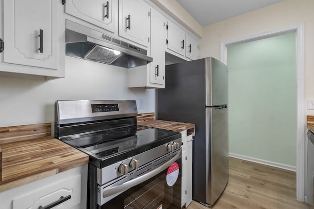 kitchen featuring white cabinets, wood counters, appliances with stainless steel finishes, and light hardwood / wood-style flooring