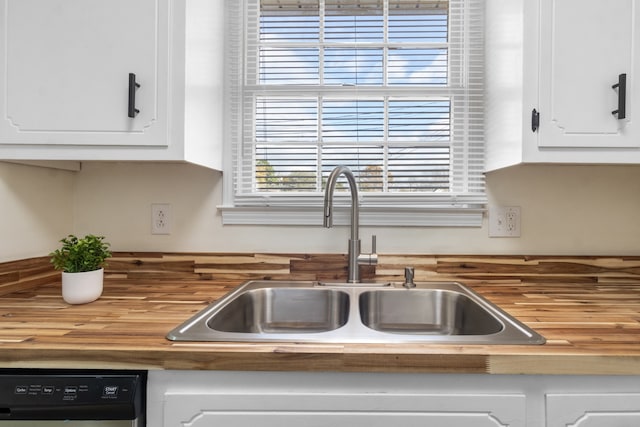 kitchen featuring white cabinetry, sink, dishwasher, and wood counters