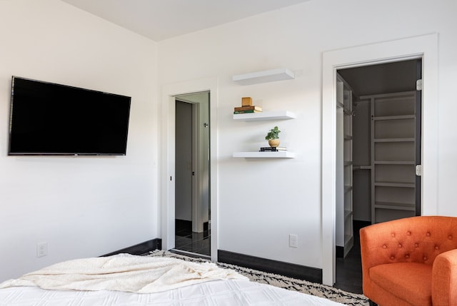 bedroom with a walk in closet, a closet, and dark hardwood / wood-style floors