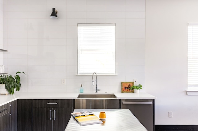 kitchen featuring modern cabinets, a sink, dark brown cabinetry, light countertops, and dishwasher