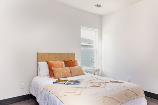 bedroom featuring visible vents, baseboards, and dark wood-style flooring