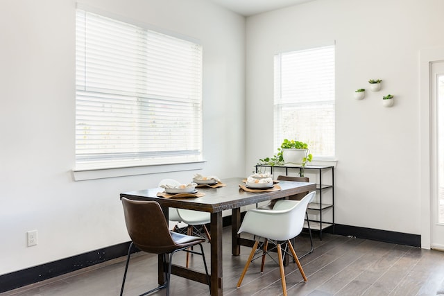 dining space with a healthy amount of sunlight and dark hardwood / wood-style flooring