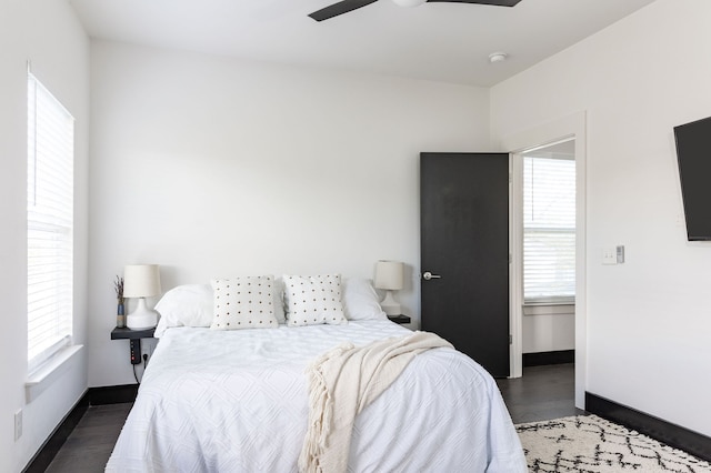 bedroom with multiple windows, ceiling fan, and dark wood-type flooring