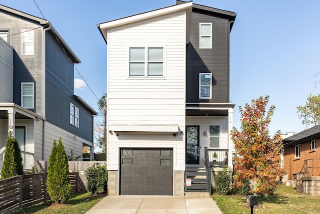 contemporary house with a garage, driveway, and fence