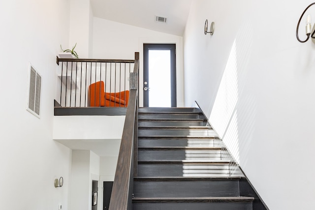 staircase with visible vents and lofted ceiling