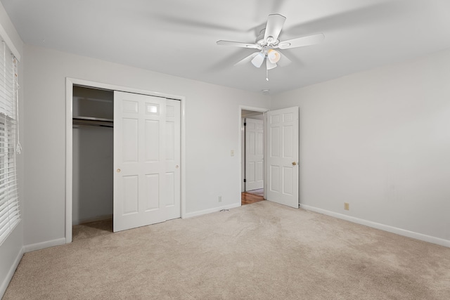 unfurnished bedroom featuring a closet, light colored carpet, and ceiling fan