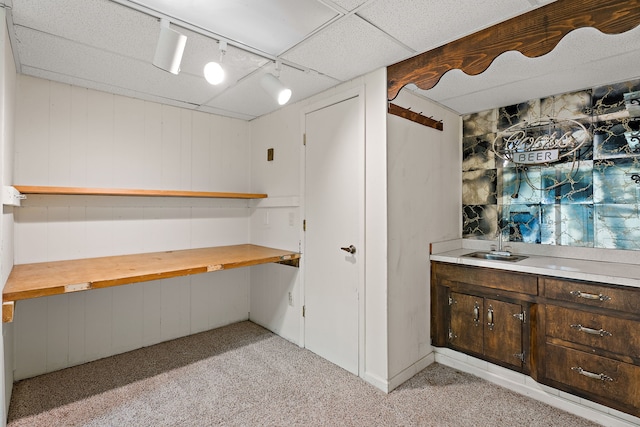 interior space with a paneled ceiling and sink