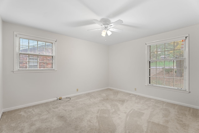 carpeted spare room with ceiling fan