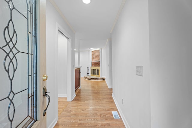 corridor featuring light hardwood / wood-style floors and ornamental molding