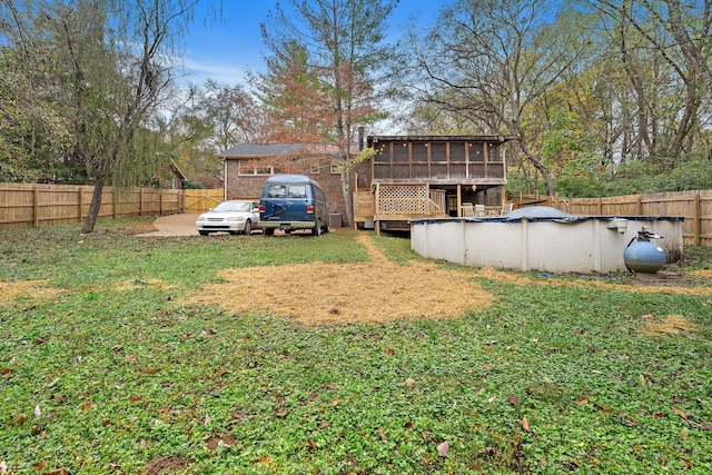 view of yard with a sunroom and a covered pool