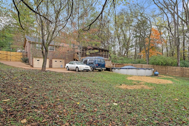 view of yard featuring a garage and a covered pool