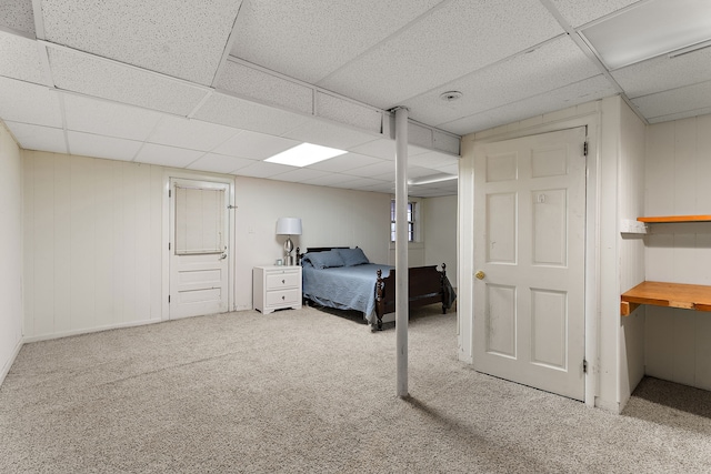 bedroom with a drop ceiling and carpet