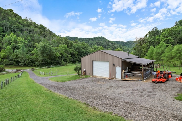 garage featuring a rural view and a lawn