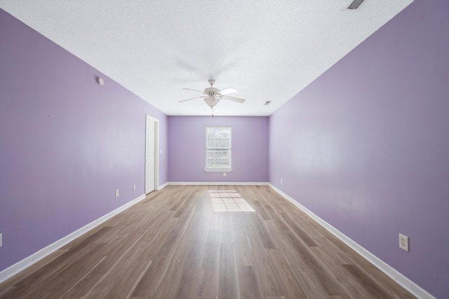 spare room with hardwood / wood-style flooring, ceiling fan, and a textured ceiling