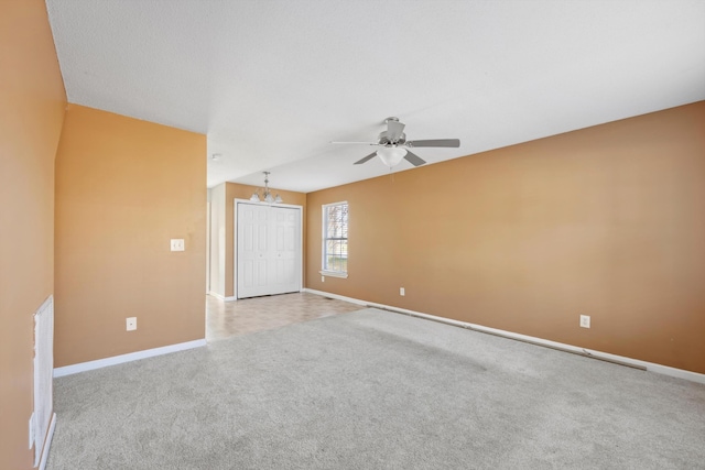 carpeted empty room with ceiling fan with notable chandelier