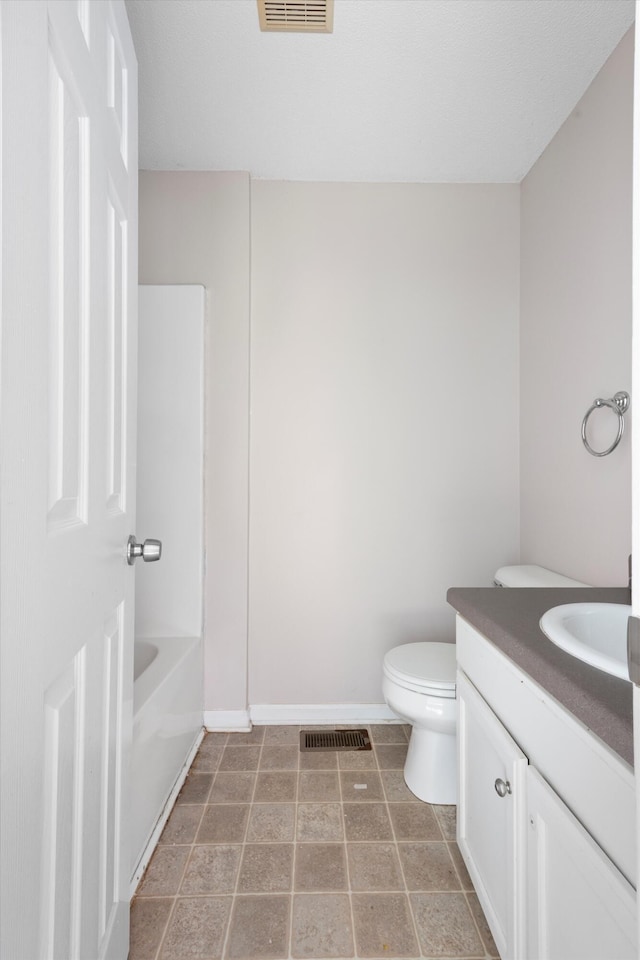 bathroom with a bath, vanity, and toilet