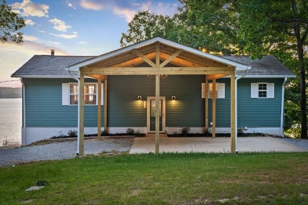 back house at dusk with a lawn