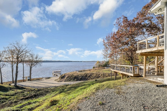 view of yard with a deck with water view