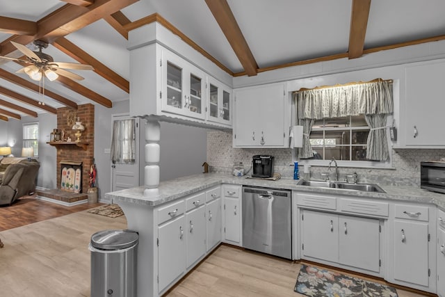 kitchen with lofted ceiling with beams, white cabinetry, sink, and stainless steel dishwasher