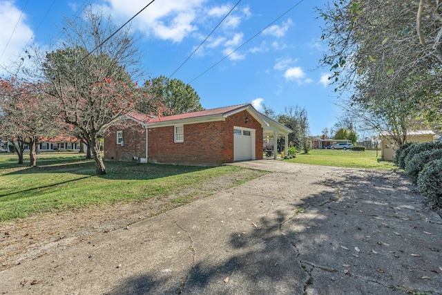 view of side of home featuring a garage and a yard