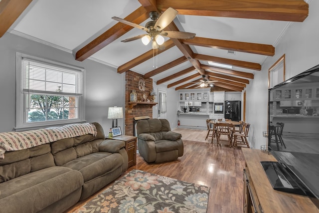 living room with ornamental molding, ceiling fan, lofted ceiling with beams, a fireplace, and light hardwood / wood-style floors