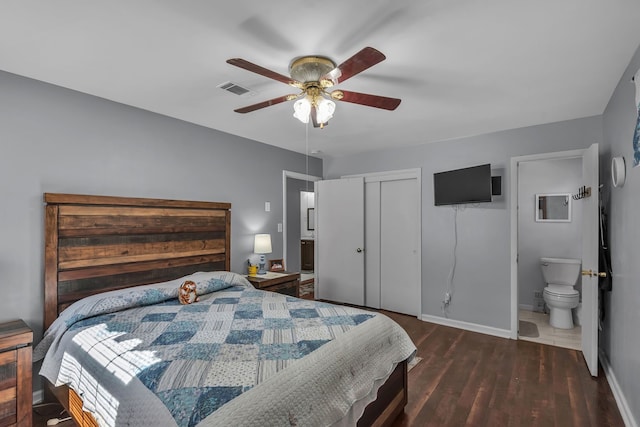 bedroom featuring a closet, connected bathroom, dark hardwood / wood-style floors, and ceiling fan