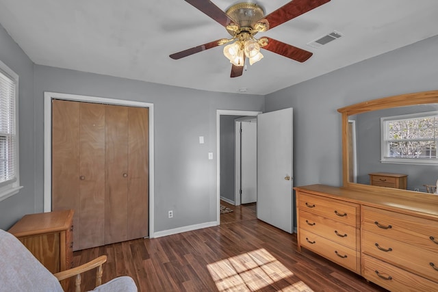 bedroom with ceiling fan, dark wood-type flooring, and a closet