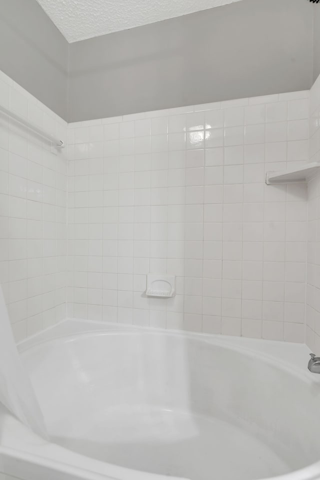 bathroom featuring a bath and a textured ceiling