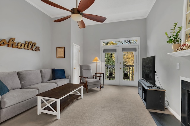 living room with french doors, crown molding, ceiling fan, a towering ceiling, and carpet floors