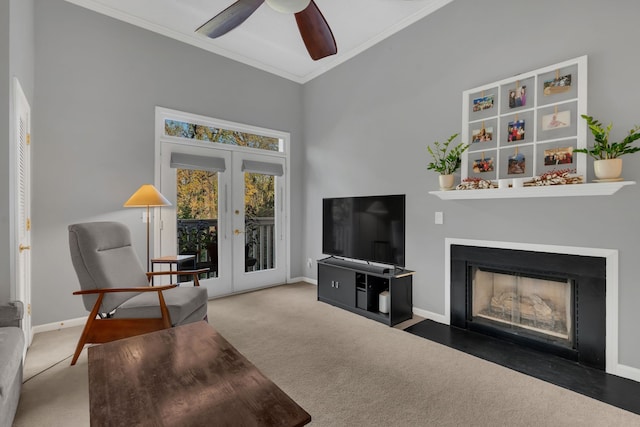 carpeted living room with french doors, ceiling fan, and crown molding