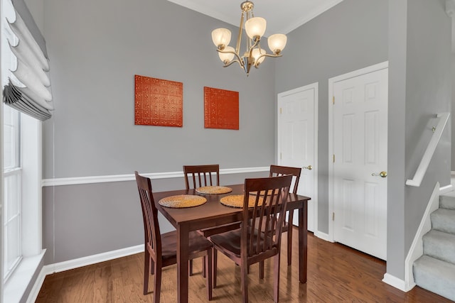 dining area featuring a healthy amount of sunlight, crown molding, dark wood-type flooring, and a chandelier