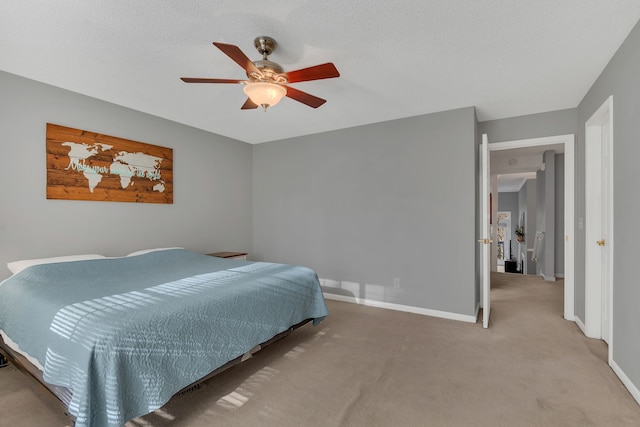 carpeted bedroom with ceiling fan and a textured ceiling