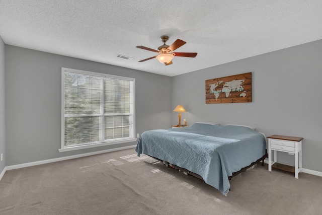 bedroom featuring ceiling fan, carpet, and a textured ceiling