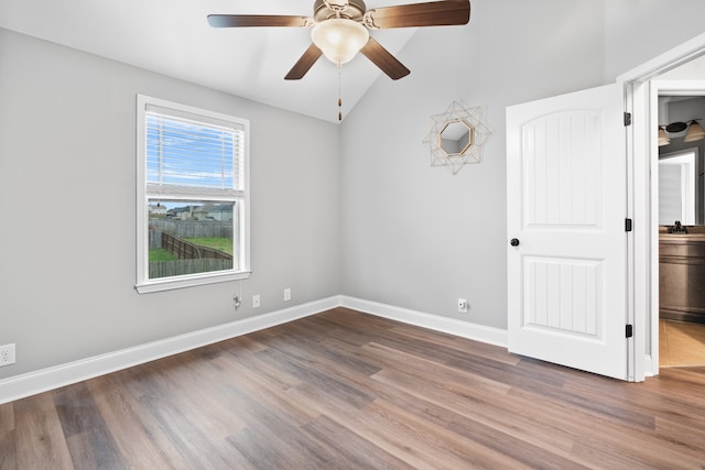 unfurnished room with ceiling fan, wood-type flooring, and vaulted ceiling