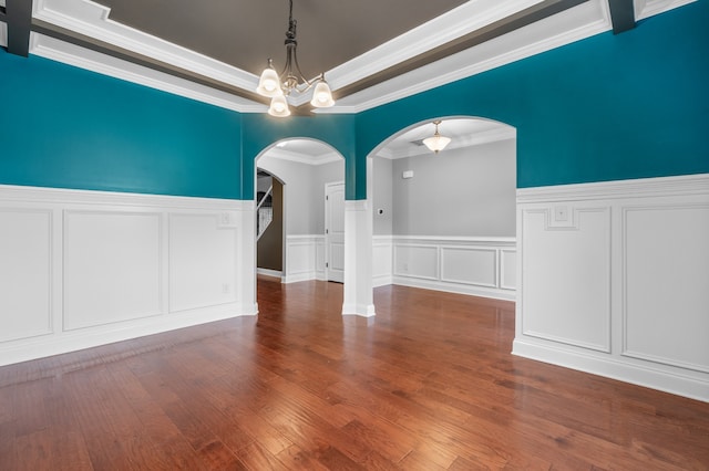 unfurnished dining area featuring a raised ceiling, crown molding, a chandelier, and hardwood / wood-style flooring