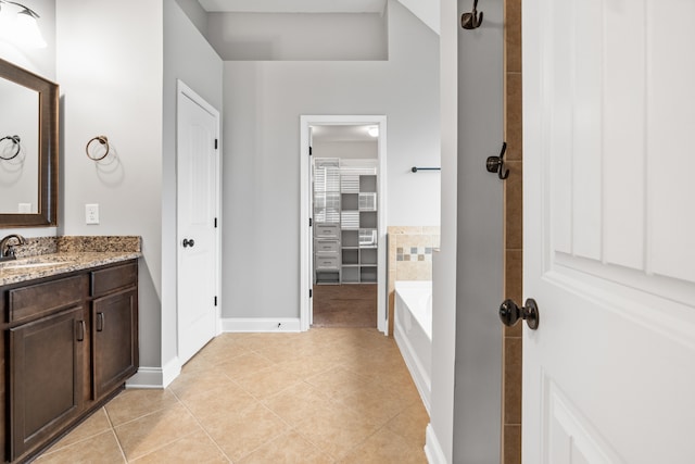 bathroom with tile patterned flooring, vanity, and a tub