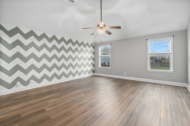 empty room featuring hardwood / wood-style flooring, ceiling fan, and a healthy amount of sunlight