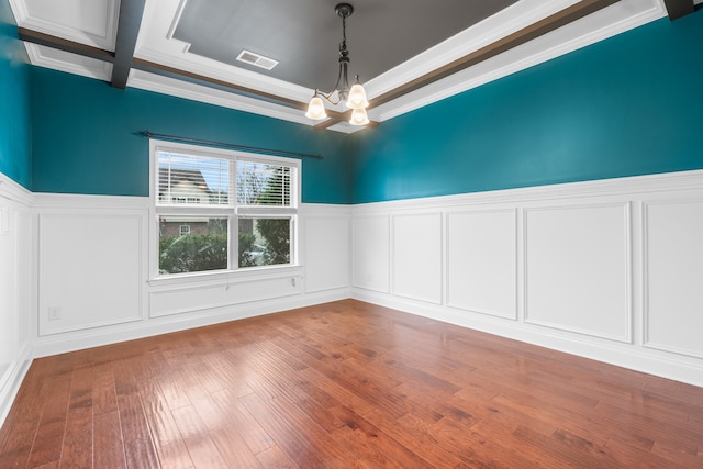 unfurnished room featuring ornamental molding, wood-type flooring, and an inviting chandelier