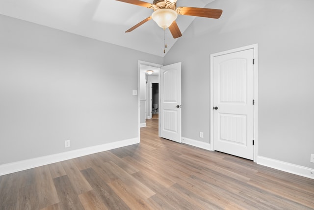 unfurnished bedroom featuring ceiling fan, light wood-type flooring, and vaulted ceiling