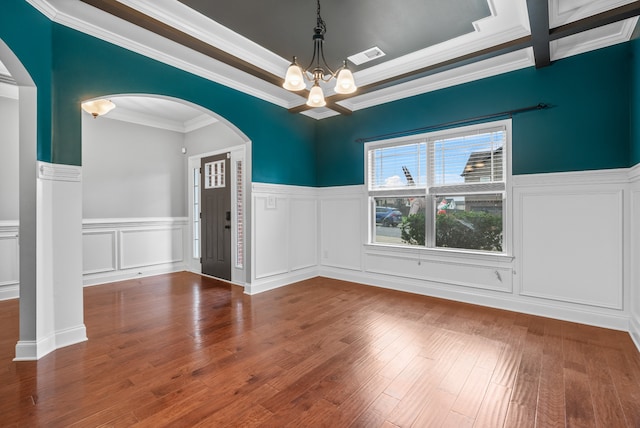 spare room with a chandelier, beamed ceiling, hardwood / wood-style flooring, and crown molding